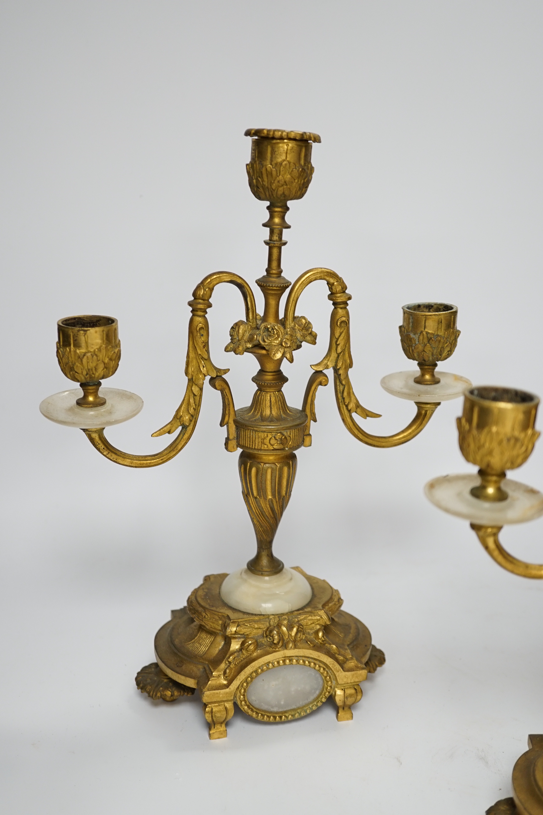 A pair of Louis XVI style ormolu and white onyx three branch candelabra, 29cm high